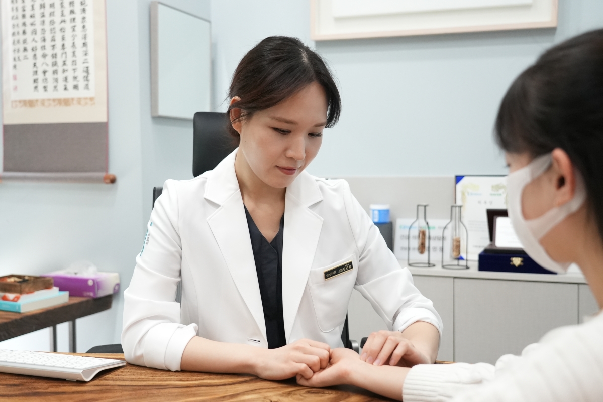 생기한의원 수원점 김민정 대표원장이 내원객과 마주 앉아 상담하고 있습니다.